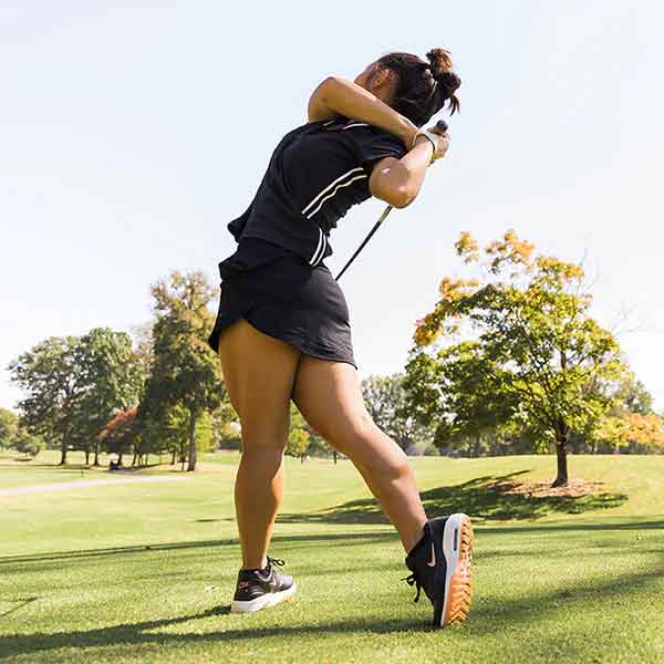 Woman playing golf, wearing Swiftwick socks