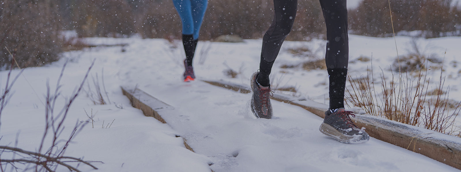 Two women running in snow wearing Swiftwick Pursuit socks