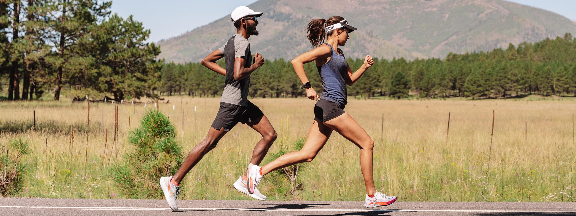 Man and woman running down a road wearing Swiftwick socks
