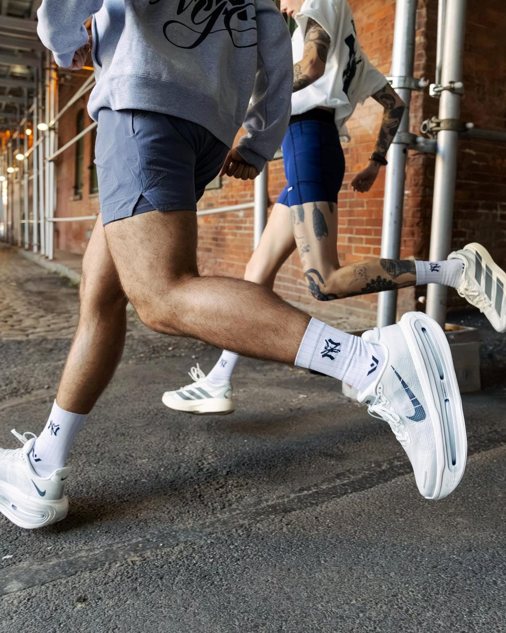 Lifestyle shot of a runner on an urban street in dark shorts and white sneakers