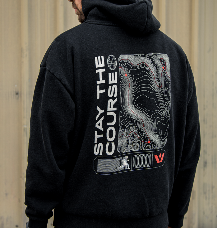 Person wearing a black Swiftwick hoodie with Stay the Course text and graphic on the back.