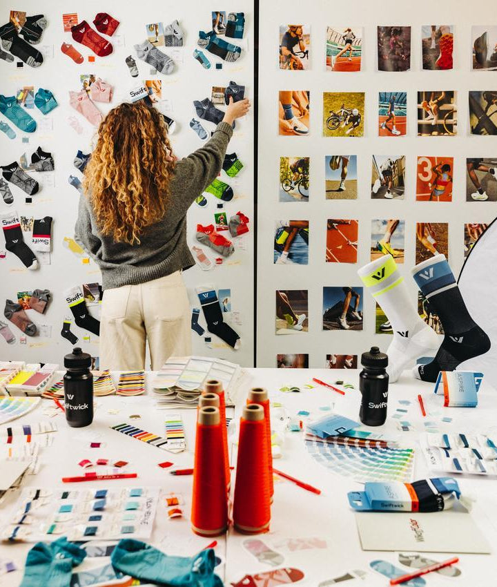 Person grabbing a sock off of a wall that has an assortment of socks and images on it