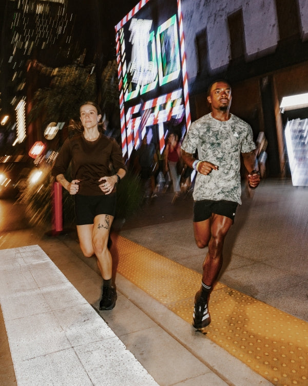 Couple walking together at night on a lit city street