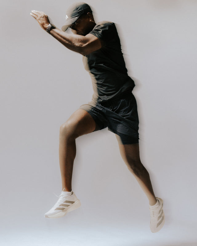 Athlete in a dark tank and shorts in a dynamic pose wearing white Maxus No Show socks